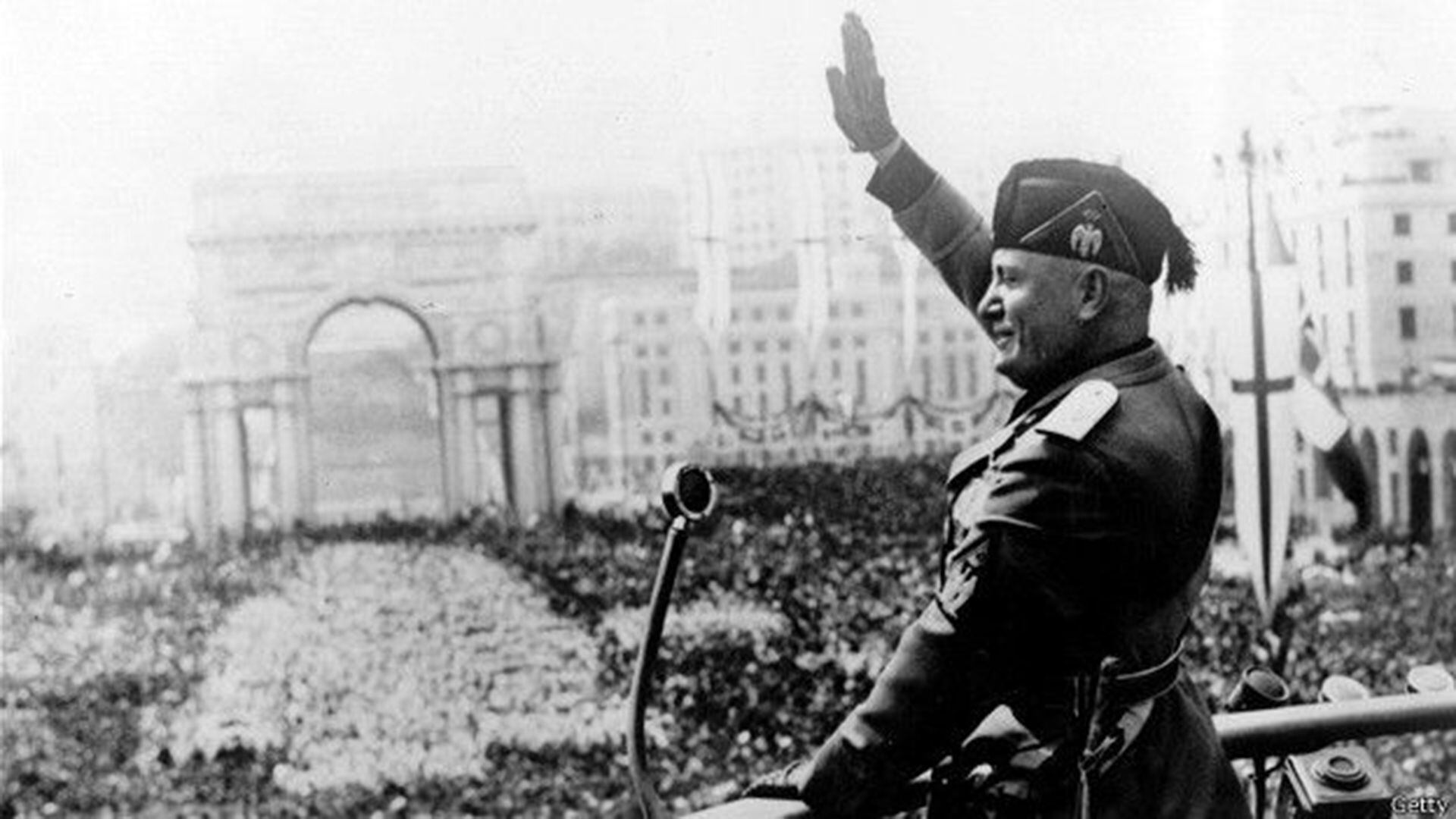 Benito Mussolini, haciendo el saludo fascista ante la multitud desde un balcón