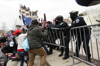 Partidarios del presidente Trump se enfrentan a los oficiales de policía fuera del edificio del Capitolio en Washington este 6 de enero de 2021. REUTERS/Leah Millis