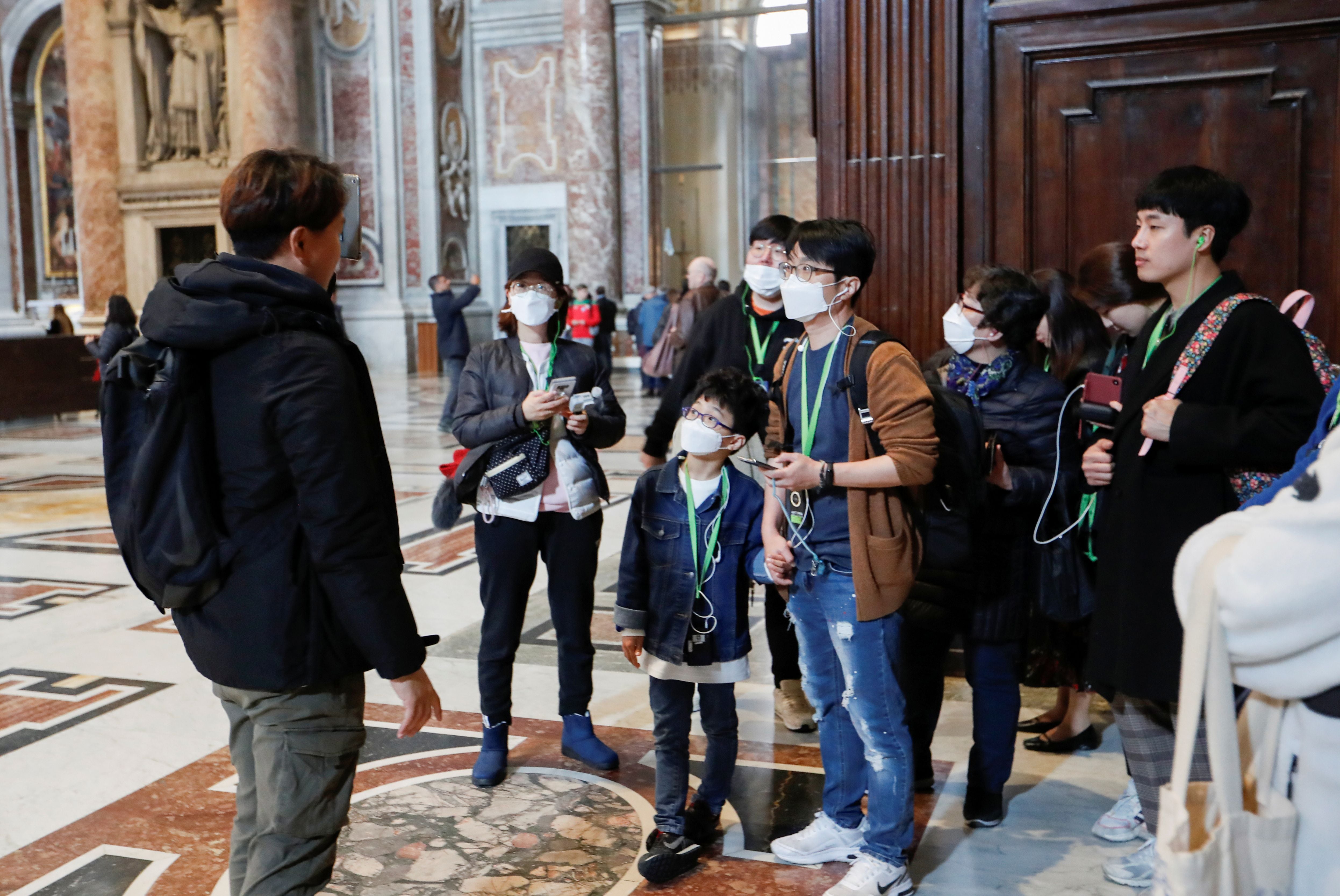 Turistas con mascarillas en la basílica de San Pedro (Reuters)