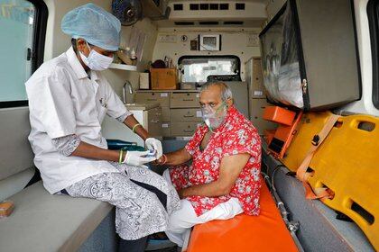 Una trabajadora sanitaria utiliza un oxímetro para comprobar el nivel de oxígeno de un paciente en una ambulancia en Ahmedabad, la India, el 22 de abril de 2021 (REUTERS/Amit Dave)