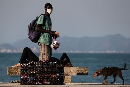 Un hombre vende lentes de sol en la playa de Copacabana en Río de Janeiro. FOTO DE ARCHIVO. Julio, 2020 REUTERS/Sergio Moraes