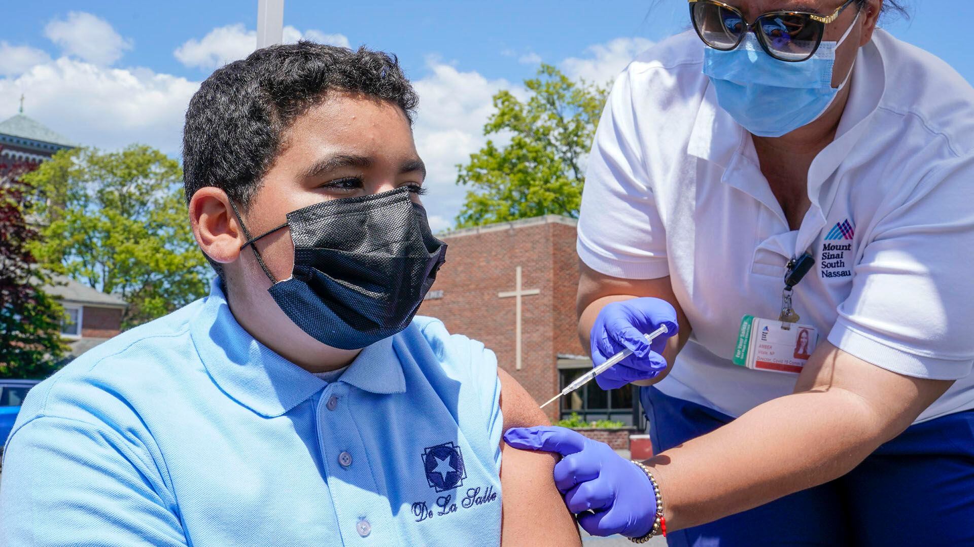 La enfermera Amber Vitale vacuna a Stanley Pena, de 13 años, con la primera dosis de la vacuna Pfizer COVID-19 en el Vaxmóvil de Mount Sinai South Nassau estacionado en la Escuela De La Salle, el viernes 14 de mayo de 2021, en Freeport, N.Y. (AP /Mary Altaffer)