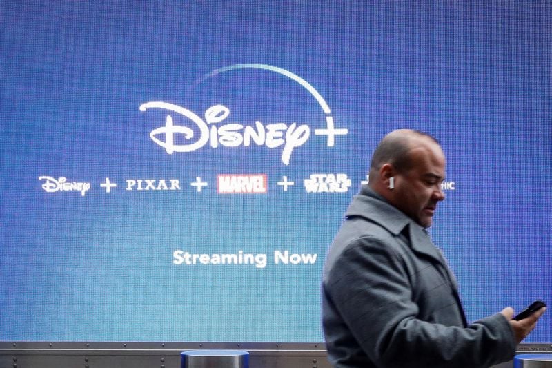 FOTO DE ARCHIVO. Un hombre mira su teléfono mientras pasa junto a una pantalla que anuncia el servicio de streaming de Walt Disney, Disney+, en Nueva York, Estados Unidos. 12 de noviembre de 2019. REUTERS/Brendan McDermid