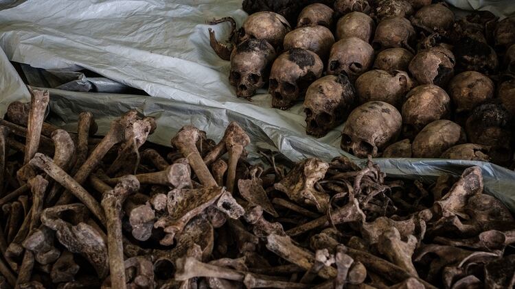 Huesos de víctimas del genocidio encontrados en una fosa común descubierta en abril de 2018 (AFP)