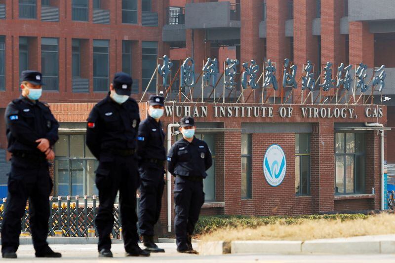 Personal de seguridad vigilando el exterior del Instituto de Virología de Wuhan durante la visita del equipo de la OMS a cargo de investigar los orígenes del COVID, en 2021 (Reuters)