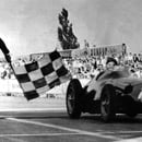 Recibiendo la bandera de cuadros en Nürburgring 1957 (Museo Fangio).