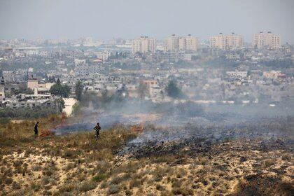 Soldados israelíes cerca de un terreno incendiado cerca de la Franja de Gaza tras el lanzamiento de globos cargados con material inflamable (REUTERS/Amir Cohen)