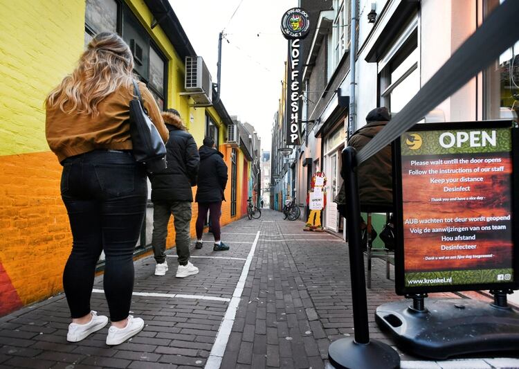 Los clientes mantienen distancia social mientras hacen cola fuera de un coffee shop que tiene permitido abrir para venta de cannabis para llevar, en Nimega, Holanda, el 31 de marzo de 2020 (REUTERS/Piroschka van de Wouw/Archivo Foto)