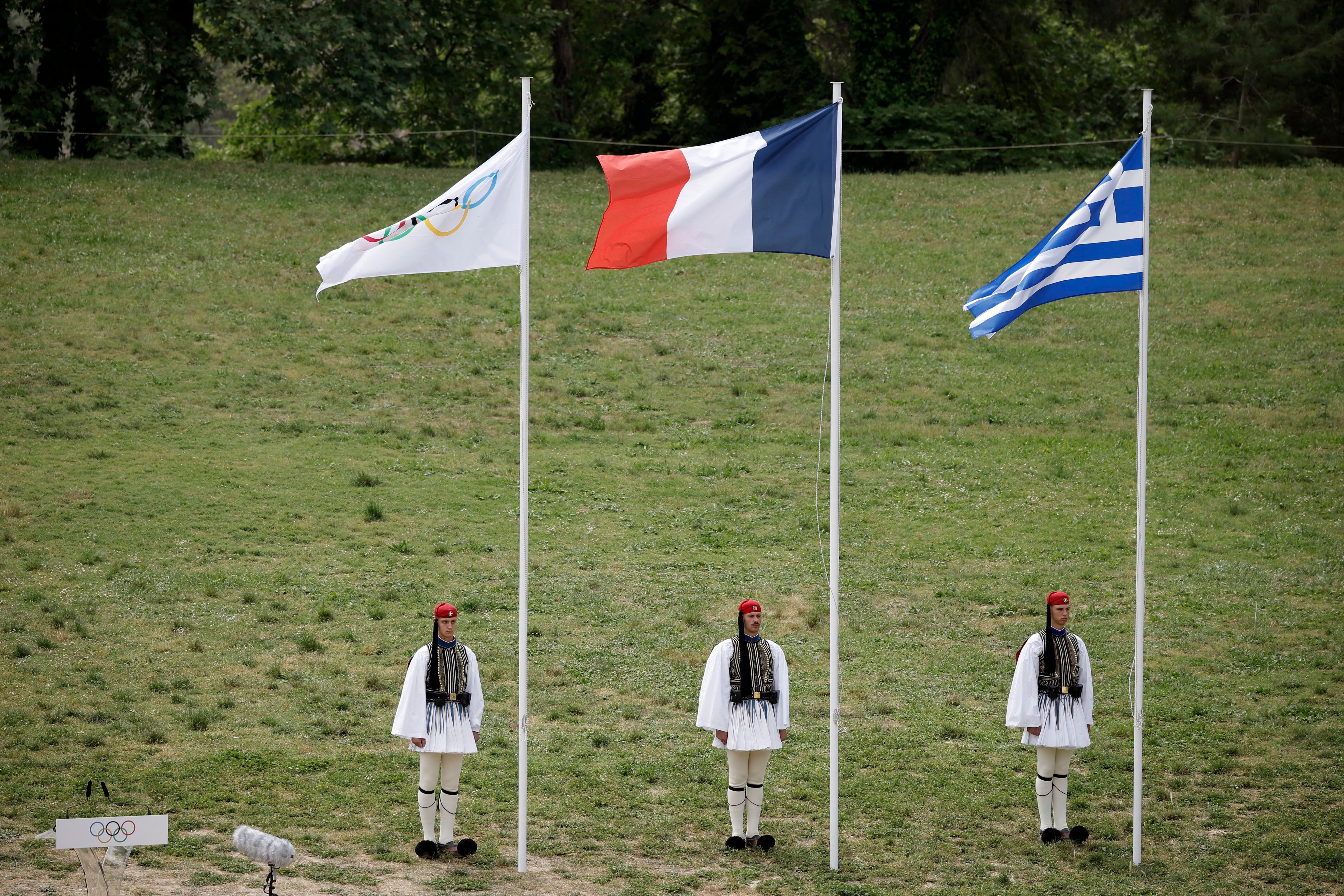 Las tres banderas durante la ceremonina de encendido: Olímpica, de Grecia y Francia