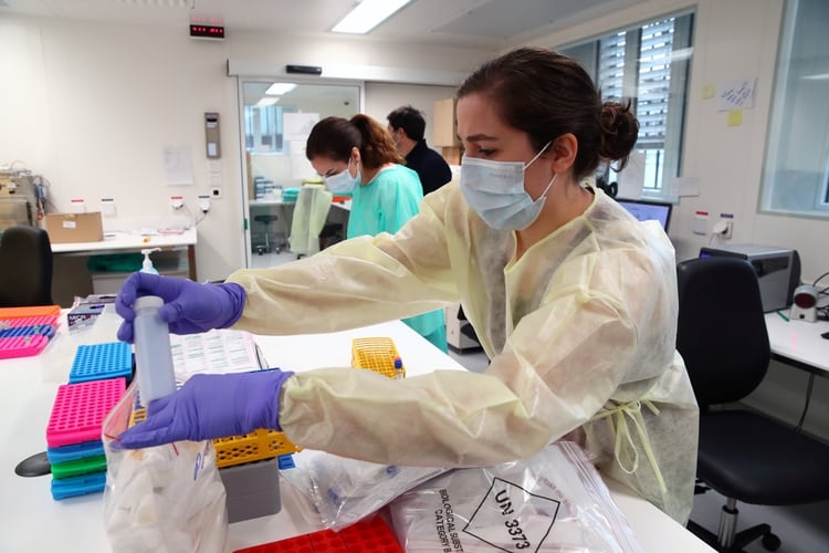Staff members work as media visit the Microbiology Laboratory of the University Hospital (CHUV) during the coronavirus disease (COVID-19) outbreak in Lausanne, Switzerland, March 23, 2020. REUTERS/Denis Balibouse