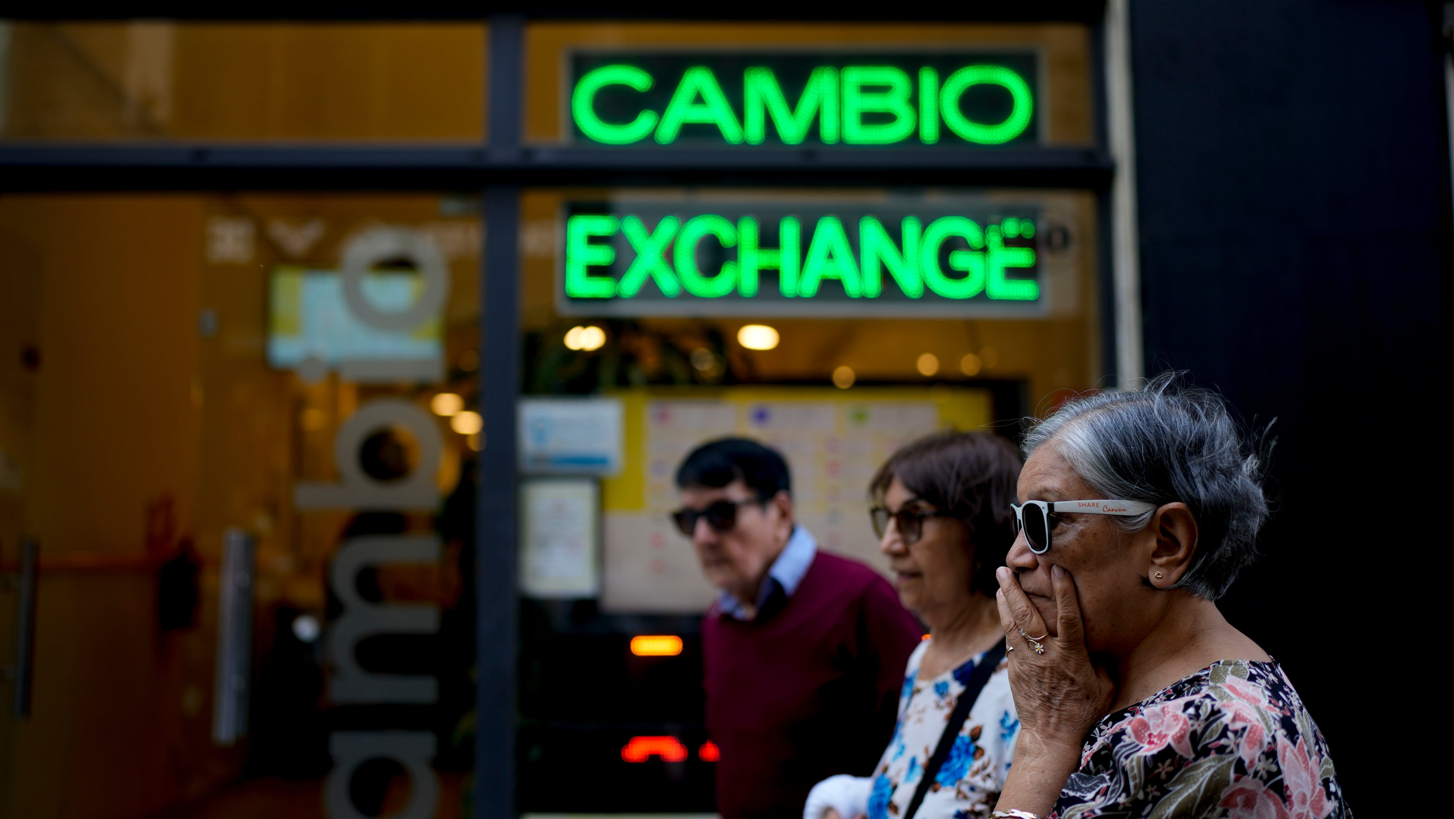 Las personas caminan frente a una casa de cambio en Buenos Aires, Argentina, el martes 10 de octubre de 2023. (AP Foto/Natacha Pisarenko)