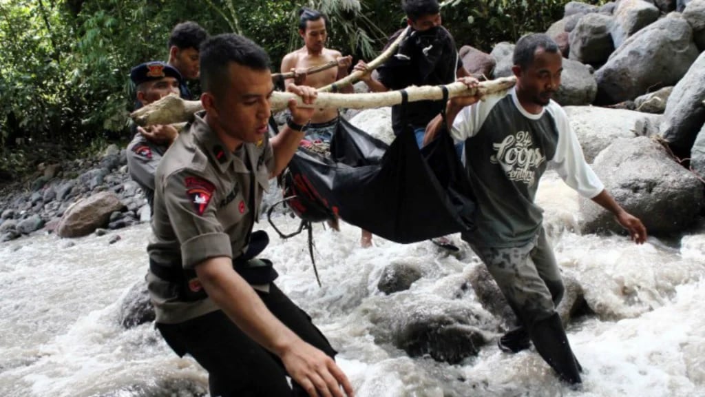 La policía traslada un cuerpo fallecido durante las inundaciones de mayo en Indonesia (AFP)