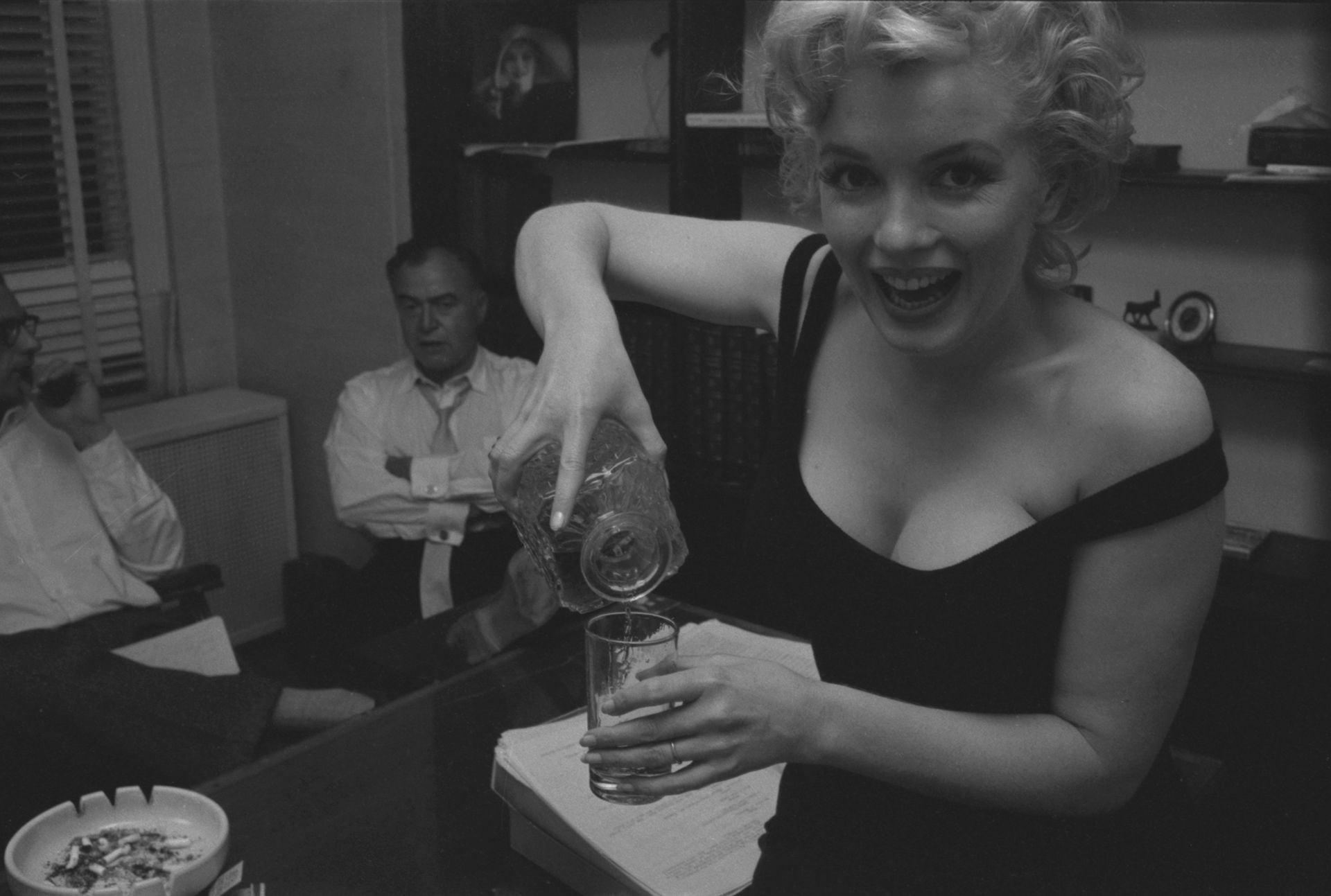 En 1958, Marilyn se sirve un vaso de whisky junto a su entonces esposo, Arthur Miller, y el productor teatral Kermit Bloomgarden. En sus últimos años, la adicción al alcohol y los barbitúricos era notoria (LIFE Collection)