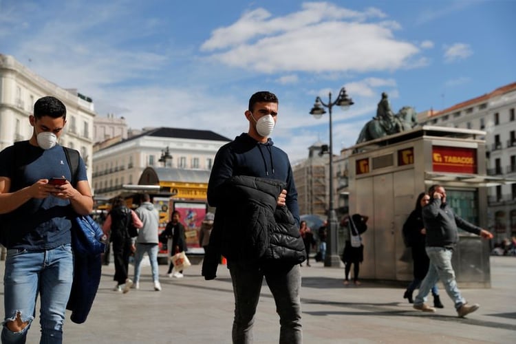 Hombres con mascarilla caminan por la Puerta del Sol, en Madrid, España (Reuters)