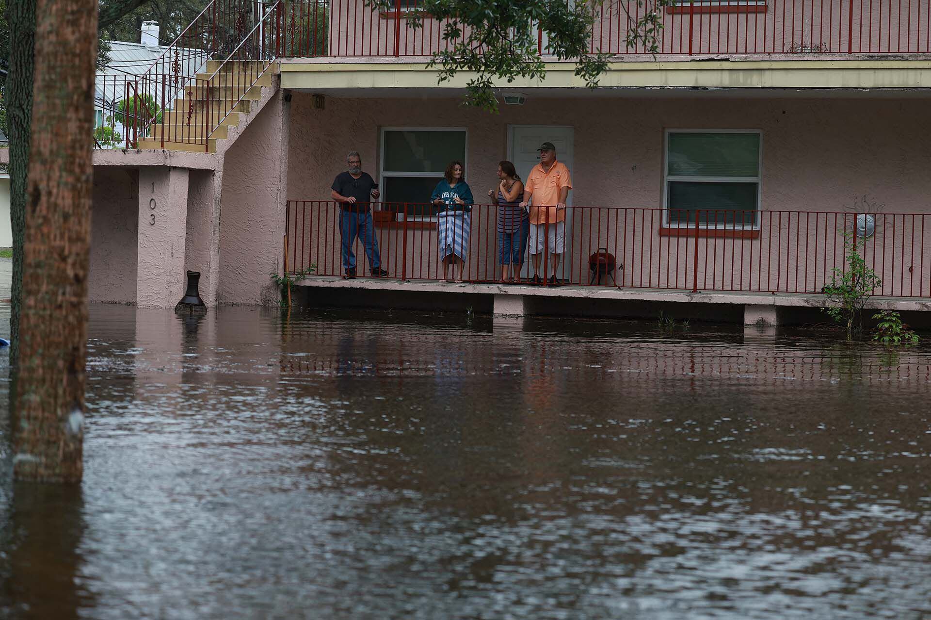 La gente observa las aguas de la inundación del huracán Idalia que rodean su complejo de apartamentos el 30 de agosto de 2023 en Tarpon Springs, Florida. Joe Raedle/Getty Images/AFP (Foto de JOE RAEDLE / GETTY IMAGES NORTEAMÉRICA / Getty Images vía AFP)