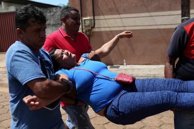 Una mujer se desmaya frente al Instituto de Medicina Legal de Altamira (REUTERS/Bruno Kelly)