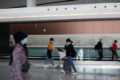 Pasajeros con mascarillas después del brote de la enfermedad por coronavirus (COVID-19) caminan en el Aeropuerto Internacional de Beijing Daxing antes del feriado del Día Nacional de China en Beijing, China, el 25 de septiembre de 2020. Foto tomada el 25 de septiembre de 2020. REUTERS / Carlos García Rawlins