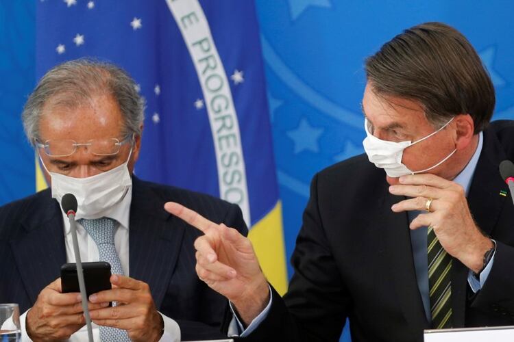 El presidente de Brasil, Jair Bolsonaro, y el ministro de Economía, Paulo Guedes, con máscaras protectoras durante una conferencia de prensa para anunciar medidas contra el coronavirus (COVID-19) en Brasilia. 18 de marzo de 2020. REUTERS/Adriano Machado