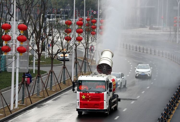 Trabajadores operan un vehículo para llevar a cabo la desinfección en el distrito de Jianghan (China Daily via REUTERS)