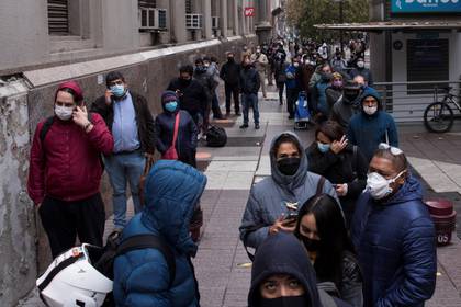 Un grupo de personas hace fila para acceder a un banco en el centro de Santiago, Chile. EFE/Alberto Valdés/Archivo
