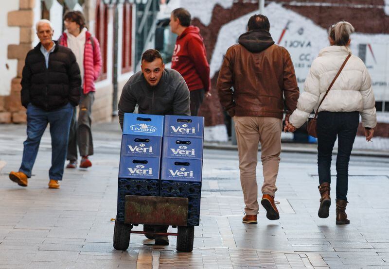 Un repartidor empuja un carro con cajas de botellas de agua en Ronda, sur de España, 3 de enero de 2023. REUTERS/Jon Nazca