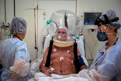 Trabajadores de la salud atienden con un casco burbuja a un paciente con la COVID-19 en la ciudad de Sao Leopoldo (Brasil). EFE/Daniel Marenco