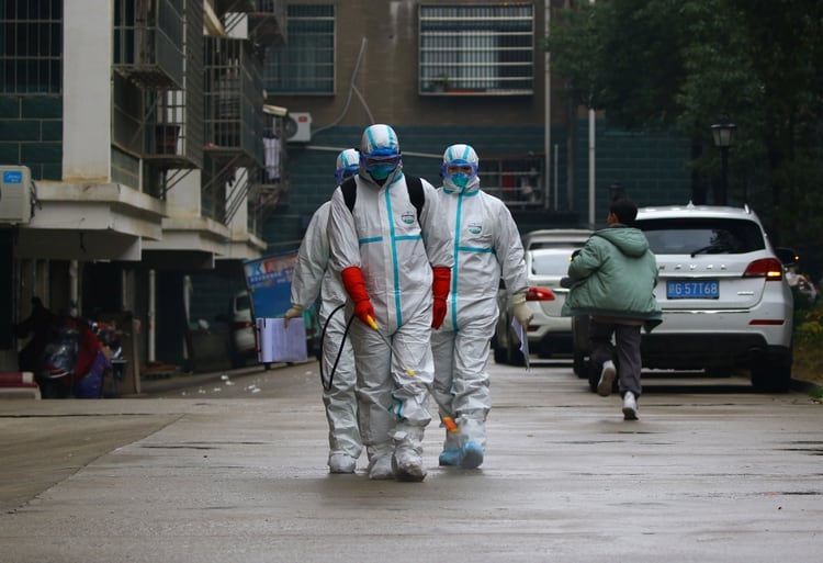Trabajadores en una unidad de control y prevención de enfermedades desinfecta un área residencial en Ruichang, provincia de Jiangxi (Reuters)