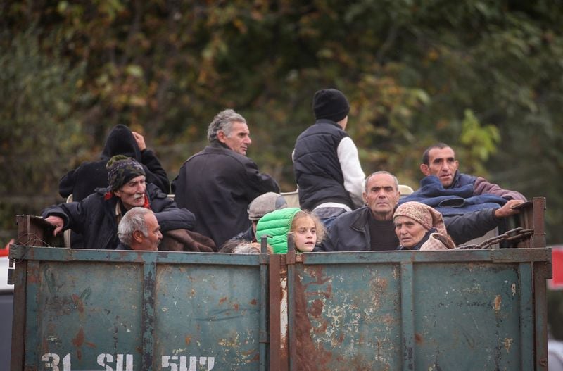 Refugiados de la región de Nagorno Karabaj viajan en la parte trasera de un camión a su llegada al pueblo fronterizo de Kornidzor, Armenia
