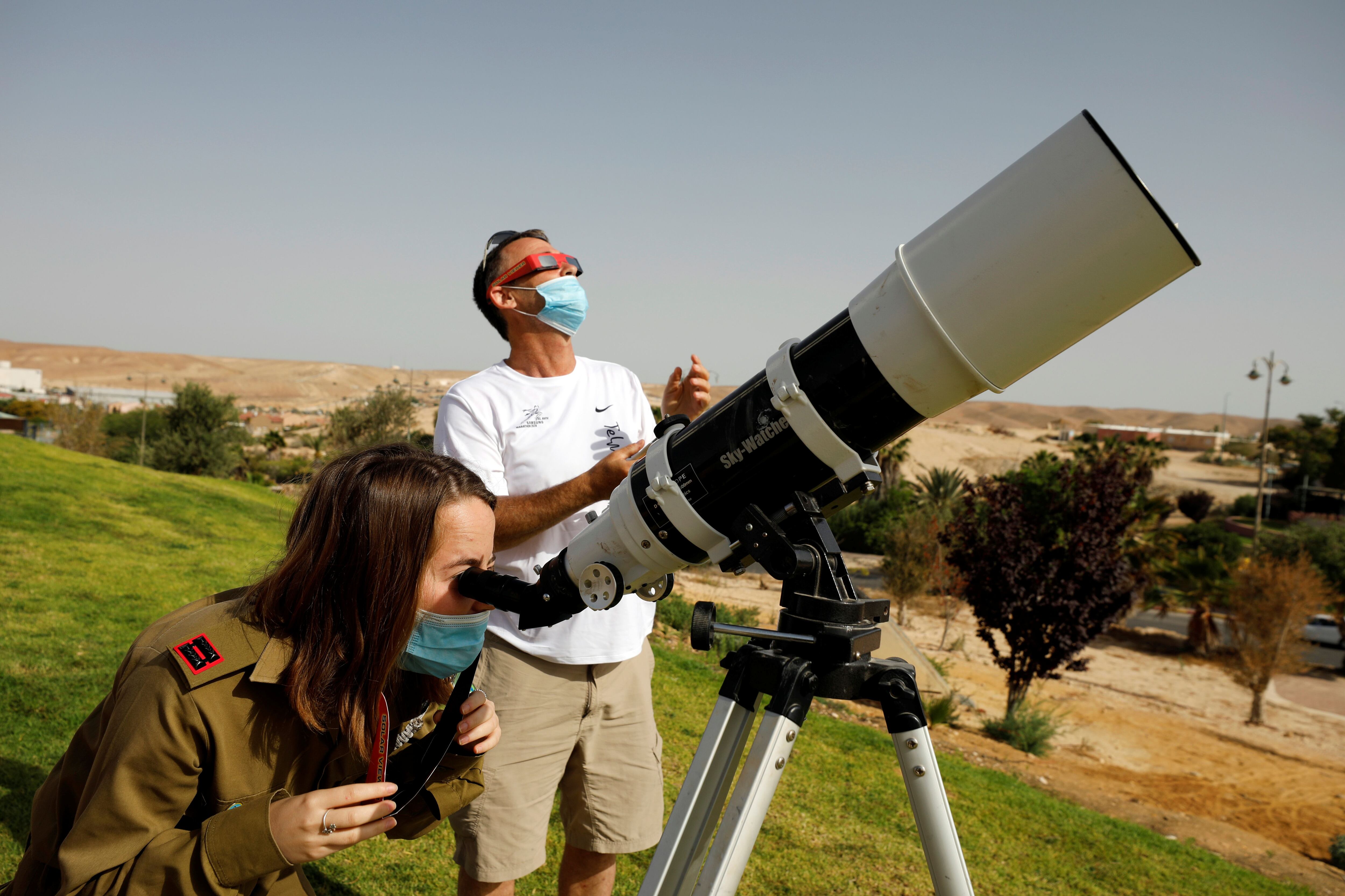 An Israeli soldier looks through a telescope as she observes a partial solar eclipse from Yeruham, southern Israel June 21, 2020. REUTERS/Amir Cohen