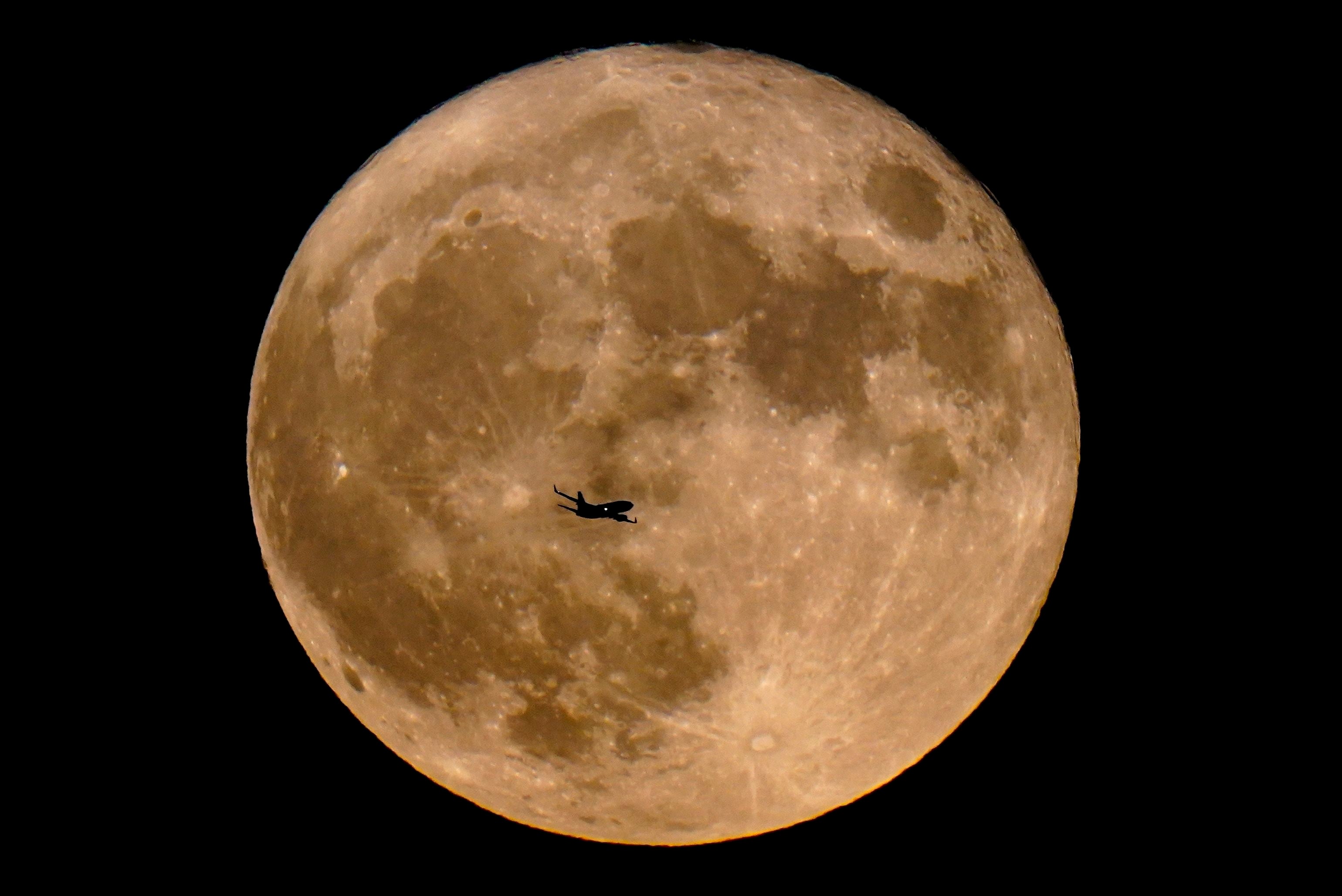 Un avión pasa frente a una superluna, el 13 de julio de 2022, en Milwaukee. (AP Foto/Morry Gash, Archivo)
