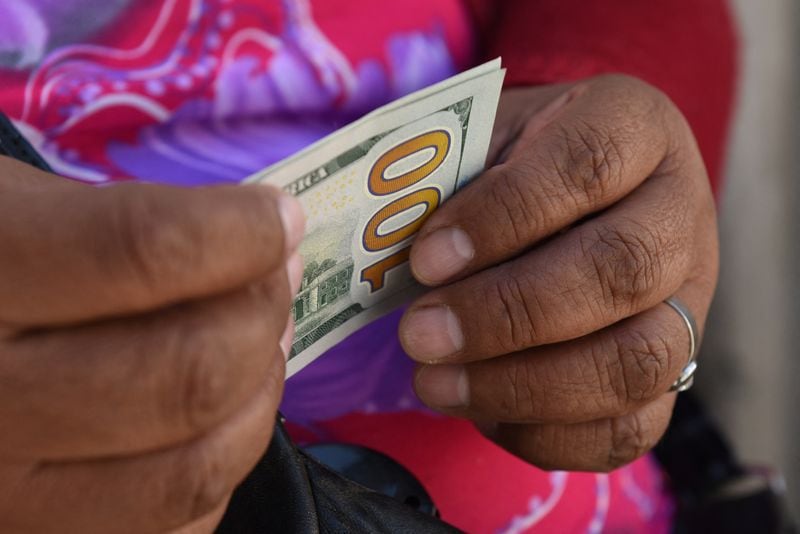 Un comerciante informal de divisas sostiene billetes de dólares estadounidenses en una calle, en La Paz (REUTERS/ Claudia Morales)