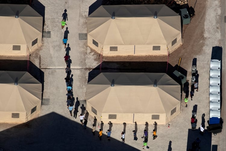 Migrantes menores caminan en fila en un centro de custodia de Texas (Archivo Reuters)