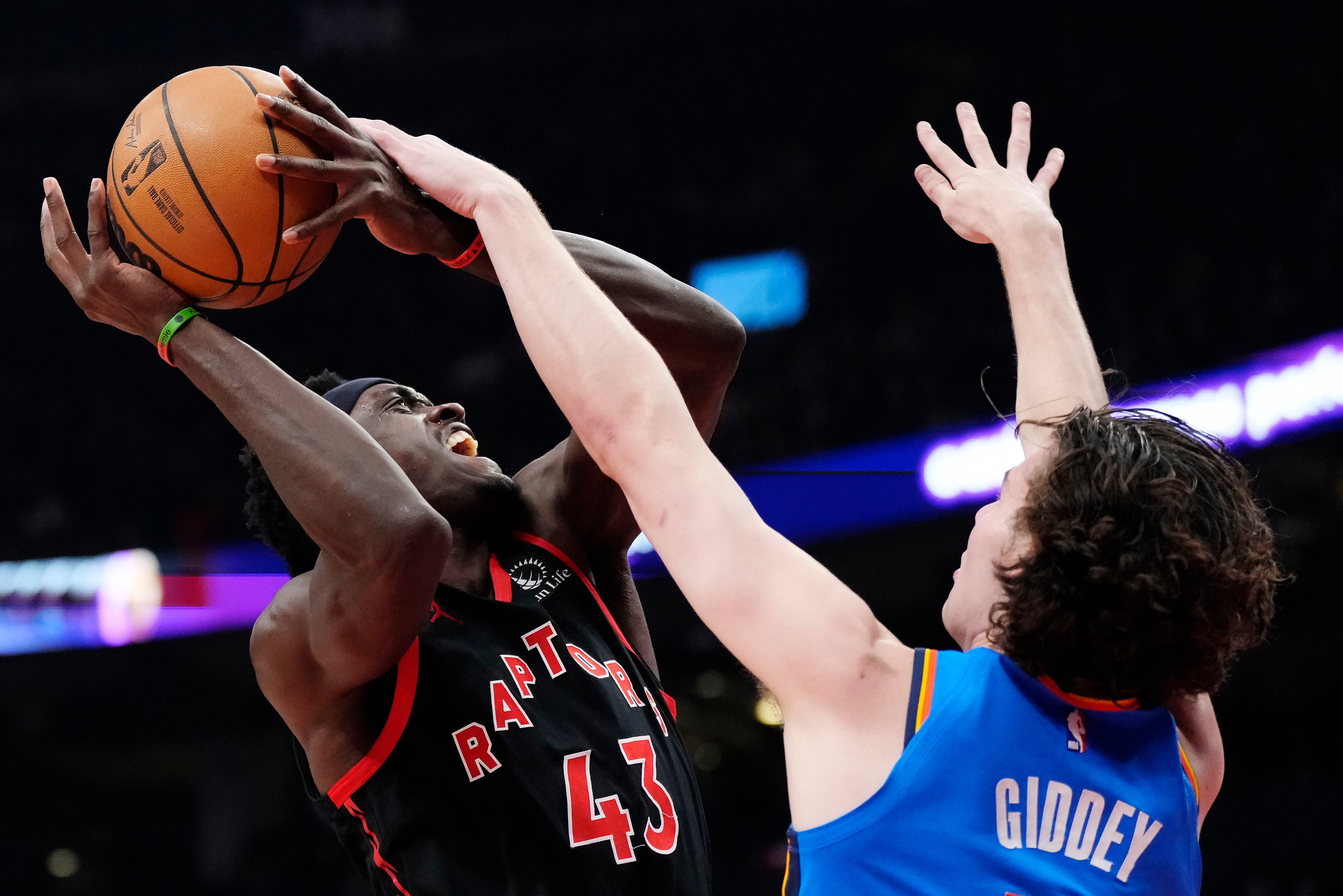 El alero del los Raptors de Toronto Pascal Siakam recibe una falta del base del Thunder de Oklahoma City Josh Giddey en el encuentro del jueves 16 de marzo del 2023. (Frank Gunn/The Canadian Press via AP)