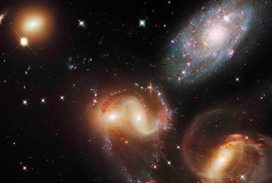 A group of five galaxies appearing close to each other in the sky: two in the center, one toward the top, one toward the upper left, and one toward the bottom, seen in a mosaic or composite of near-infrared and semi-infrared data from NASA's James Webb Space Telescope.