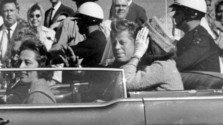 FILE - In this Nov. 22, 1963 file photo, President John F. Kennedy waves from his car in a motorcade in Dallas. Riding with Kennedy are First Lady Jacqueline Kennedy, right, Nellie Connally, second from left, and her husband, Texas Gov. John Connally, far left. The National Archives released the John F. Kennedy assassination files on Thursday, Oct. 26, 2017. (AP Photo/Jim Altgens, File)