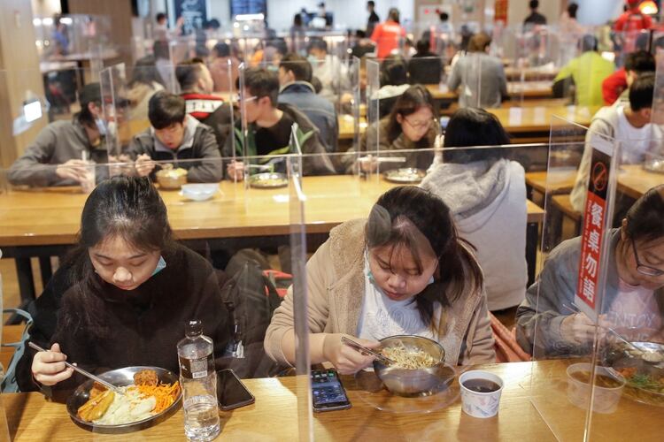 Estudiantes almuerzan entre divisores para protegerlos del coronavirus en la cantina de la Universidad Nacional de Ciencia y Tecnología de Taiwán (NTUST) en Taipei (Reuters)