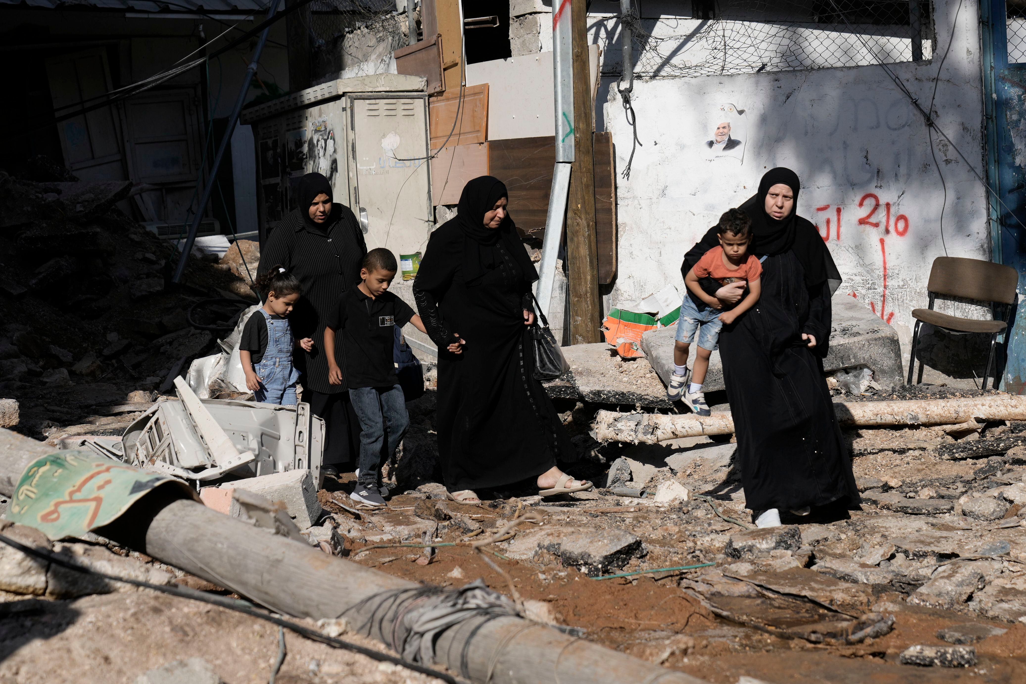 Mujeres y niños revisan la destrucción causada por una incursión del ejército israelí en el campo de refugiados palestinos de Nur Shams, en Cisjordania (AP Foto/Majdi Mohammed)