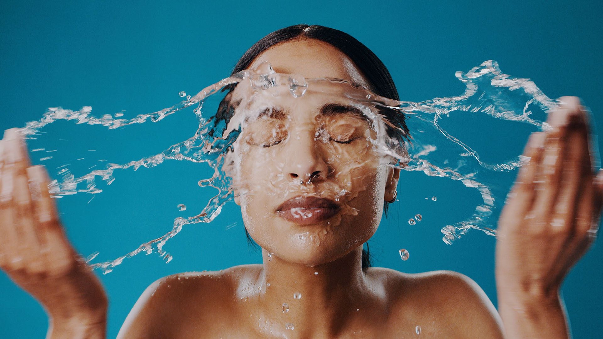 Mujer se aplica agua en la cara