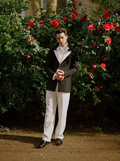 El actor Josh O’connor lució un esmoquin de saco negro con el distintivo de solapa blanca, camisa off white y pantalón negro. Completó el estilismo con zapatos de cuero negro (@goldenglobes)