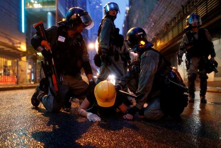 Un grupo de policías detiene a un manifestante (REUTERS/Thomas Peter)