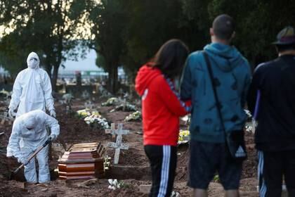 Foto del viernes de un grupo de trabajadores y familiares en un cementerio en Río de Janeiro  durante el entierro de Neide Rodrigues, de 71 años, quien falleció de coronavirus. May 8, 2020. REUTERS/Pilar Olivares