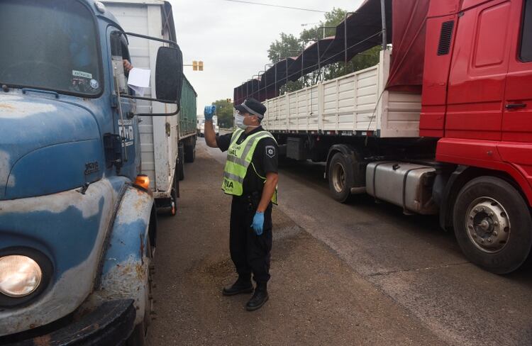 Un policía controla el permiso de un camionero en Roldán, Santa Fe