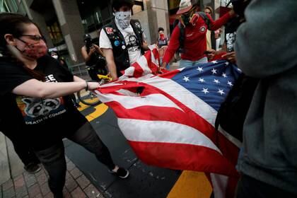 Manifestantes rompen la bandera de EEUU