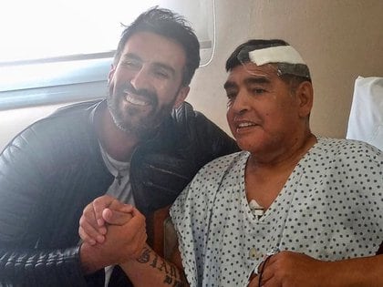 El ex futbolista argentino junto a su médico Leopoldo Luque luego de ser operado en la Clínica Olivos