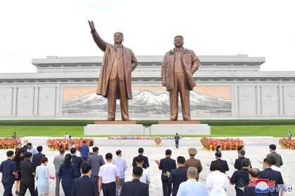 Norcoreanos se reúnen frente a las estatuas de los difuntos líderes Kim Il Sung y Kim Jong Il mientras celebran el Día de la Fundación, conmemorando la fundación del país en Pyongyang el 9 de septiembre de 2020 (KCNA vía REUTERS)