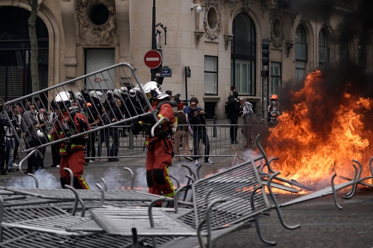 Bomberos trabajan para extinguir el fuego encendido por los manifestantes (AFP)