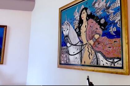 Un cuadro de Maribel semidesnuda montando un arcoiris adorna la sala principal (Foto: captura de pantalla)