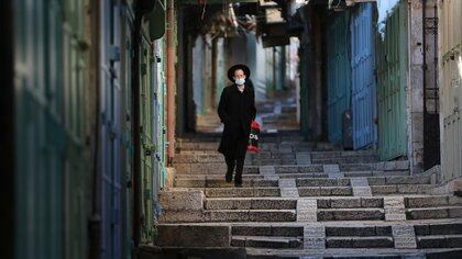 An ultra-Orthodox Jewish man walks past shuttered shops in a market during a third national lockdown imposed by Israel to fight climbing coronavirus disease (COVID-19) infections, in Jerusalem's Old City December 29, 2020. REUTERS/Ammar Awad