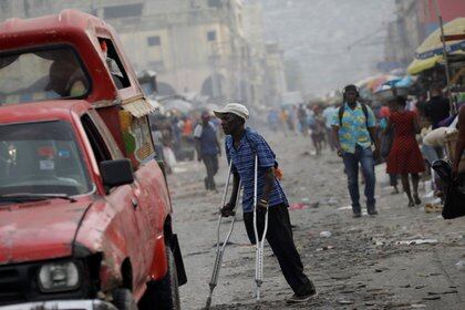 A man walks with crutches along a street in Port-au-Prince, Haiti, December 2, 2020. REUTERS/Andres Martinez Casares