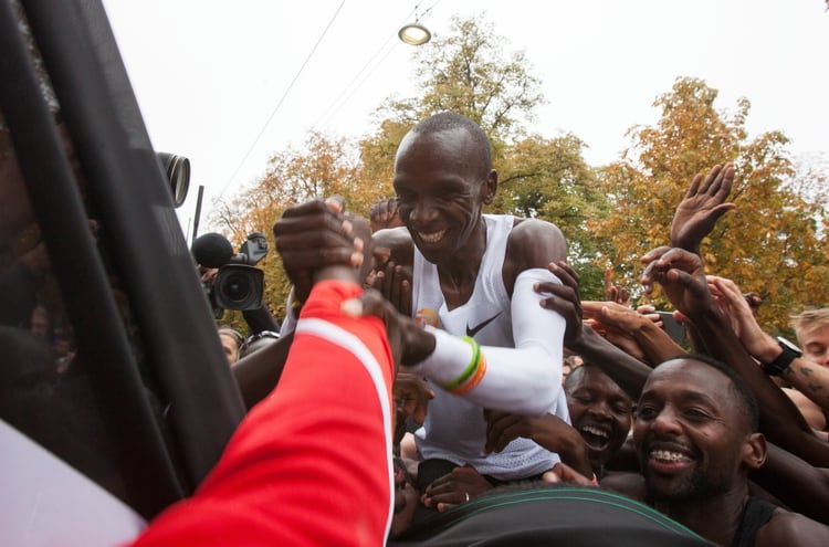 El público celebra con Eliud Kipchoge su récord histórico en la maratón (Photo by Alex Halada / AFP)